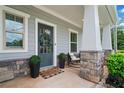Inviting front porch with stone accents and a decorated entry door at 100 Grove View Rd, Woodstock, GA 30189
