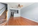 Spacious living room with hardwood floors, ceiling fan, staircase, and light blue walls at 4670 Ernest Dr, Forest Park, GA 30297