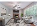 Cozy living room with brick fireplace, plush seating, patterned rug, and bright window views at 1076 Plantation Se Blvd, Conyers, GA 30094