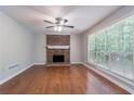 Spacious living room features a brick fireplace, ceiling fan, and lots of natural light at 1076 Plantation Se Blvd, Conyers, GA 30094