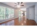 Open-concept living area with hardwood floors, a large window, and access to the kitchen and patio at 1076 Plantation Se Blvd, Conyers, GA 30094