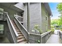 Condo exterior featuring wood siding, stairs leading to the entrance, and lush greenery around the building at 205 Tuxworth Cir # 205, Decatur, GA 30033