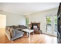 Bright living room with fireplace, wood floors, and access to a balcony through sliding glass doors at 205 Tuxworth Cir # 205, Decatur, GA 30033