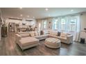 Open-concept living space with hardwood floors, a sectional sofa, and an adjacent kitchen and dining area at 688 Saffron Blvd, Lawrenceville, GA 30045