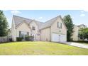 Charming two-story home featuring a two-car garage and a well-maintained front lawn on a clear, sunny day at 7270 Williamsburg Dr, Riverdale, GA 30274