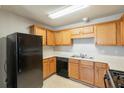 This kitchen features oak cabinets, a black gas range, a black dishwasher, and a double-basin sink at 3531 Brookstone Way, Union City, GA 30291