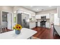 Modern kitchen with stainless steel appliances, white cabinets, and hardwood floors, next to a breakfast area at 5010 Foxberry Ln, Roswell, GA 30075