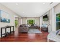 Bright living room with hardwood floors, a stone accent wall, and large windows overlooking the backyard at 5010 Foxberry Ln, Roswell, GA 30075