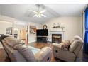 Bright living room showcasing hardwood floors, a fireplace, ceiling fan, and an open layout at 142 Old Hampton Way, Hampton, GA 30228