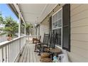 Relaxing porch featuring rocking chairs, string lights, and a view of the surrounding trees at 142 Old Hampton Way, Hampton, GA 30228