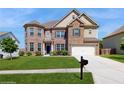 Traditional brick home with manicured lawn, featuring a two-car garage and a driveway, under a clear sky at 205 Kestrel Cir, Covington, GA 30014