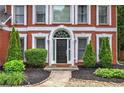 Up close image of a red brick home with manicured landscaping and front door at 3186 Sail Winds Nw Dr, Acworth, GA 30101