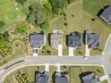 Aerial view of homes showcasing well-manicured lawns and long driveways in a desirable neighborhood setting at 3525 Brynhurst Dr, Cumming, GA 30028