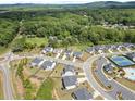 Aerial view of a community showcasing craftsman homes, a swimming pool, tennis courts, and mature trees at 3525 Brynhurst Dr, Cumming, GA 30028