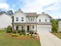 Charming two-story home with a manicured lawn, inviting front porch, and attached garage at 3525 Brynhurst Dr, Cumming, GA 30028