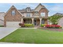 Charming two-story home with a well-manicured lawn, stone and siding exterior, and welcoming front porch at 3939 Soft Wind Ter, Buford, GA 30518