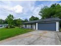 Wide driveway leads up to a charming single-story home with an attached garage and cozy porch at 1451 Brays Mill Trce, Lawrenceville, GA 30044