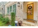 Charming entryway with a bright yellow door, brick facade, and well-manicured landscaping at 976 Memorial Se Walk, Atlanta, GA 30316