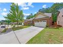 Beautiful home with a well-manicured lawn and a long driveway leading to a two-car garage at 2212 Nichols Valley Drive, Dacula, GA 30019