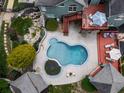 Aerial view of an in-ground pool, deck, and patio furniture in a beautifully landscaped backyard at 302 Gilmer Ct, Canton, GA 30115