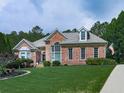 Beautiful brick home with a well-maintained lawn, mature trees, and traditional design elements at 302 Gilmer Ct, Canton, GA 30115