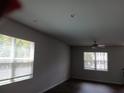 A well-lit living room with dark wood floors, two windows with white blinds, and a ceiling fan at 3242 Cascade Parc Sw Blvd, Atlanta, GA 30311