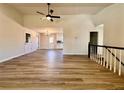 Spacious living room featuring modern wood flooring, a ceiling fan, and views into the kitchen and dining area at 2535 Impala Dr, Cumming, GA 30041