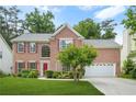 Beautiful brick home with lush greenery, featuring a well-maintained lawn and a welcoming two-car garage at 5070 Saddle Bridge Ln, Alpharetta, GA 30022