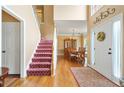 Elegant foyer with hardwood floors, a staircase with patterned runner, and views of the formal dining room at 5070 Saddle Bridge Ln, Alpharetta, GA 30022