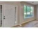 Bright foyer with hardwood floors, a large window, and a six-panel front door at 6170 Winston Trce, Mcdonough, GA 30252