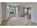 Open-concept living room with hardwood floors, large windows, and neutral paint at 6170 Winston Trce, Mcdonough, GA 30252