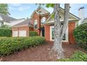 Attractive brick facade with large windows, manicured shrubs, and mature trees enhancing the curb appeal at 1996 Wellesley Trce, Atlanta, GA 30338