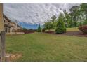 Expansive, well-maintained backyard with a lush lawn, mature trees, and privacy fencing for outdoor enjoyment at 4952 Terrace Dr, Ellenwood, GA 30294