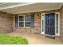 Inviting front entrance features a dark-colored door, sidelights, and brick surround with green bushes and an outdoor light at 4952 Terrace Dr, Ellenwood, GA 30294