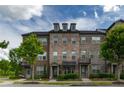 Well-maintained brick townhome with manicured landscaping and charming curb appeal at 10143 Windalier Way, Roswell, GA 30076