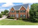 A beautiful two-story brick home boasts lush landscaping and classic architectural design at 1402 Bromley Dr, Snellville, GA 30078