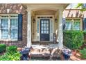 Welcoming front porch with decorative columns, charming planters, and a stylish multi-pane front door at 1584 Heartland Path, Hoschton, GA 30548