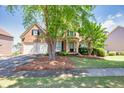 Charming two-story brick home featuring a well-manicured lawn and a two-car garage at 1584 Heartland Path, Hoschton, GA 30548