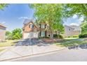 Charming two-story brick home featuring a well-manicured lawn and a two-car garage at 1584 Heartland Path, Hoschton, GA 30548