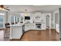 Bright, open kitchen featuring white cabinets, stainless steel appliances, and a large center island with bar seating at 1584 Heartland Path, Hoschton, GA 30548