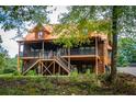Rustic log cabin-style home with a metal roof and a spacious deck and outdoor staircase at 6980 Lamplighter Ln, Winston, GA 30187