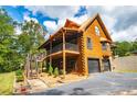 Beautiful log home with a large deck, garage, and well-manicured landscaping at 6980 Lamplighter Ln, Winston, GA 30187