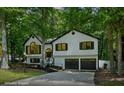 Traditional home with black window trim, a two-car garage, and lush green trees at 193 Cedar Creek Dr, Dallas, GA 30157