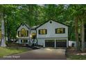 Traditional home with black window trim, a two-car garage, and lush green trees at 193 Cedar Creek Dr, Dallas, GA 30157