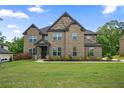 A beautifully landscaped front yard and an elegant two-story brick home at 317 Basel Way, Hampton, GA 30228