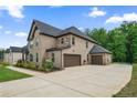 Brick two-story home with a spacious driveway and attached two-car garage at 317 Basel Way, Hampton, GA 30228