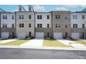 A view of newly built townhomes showcasing varying brick and siding styles and one car garages at 4962 Villager Ln, Stone Mountain, GA 30083