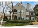 Two-story condo with a green exterior, a screened porch, and attractive landscaping at 500 Bainbridge Dr, Atlanta, GA 30327