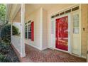 Close-up of the front entrance featuring a red front door, red shutters, and brick walkway at 4481 Mccart Cv, Stone Mountain, GA 30083
