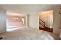 Open-concept living room featuring elegant chandelier lighting, wainscoting and easy access to the staircase and main floor at 4481 Mccart Cv, Stone Mountain, GA 30083